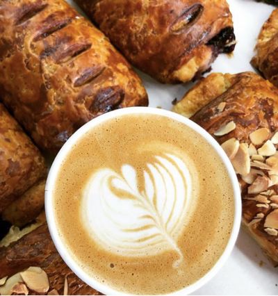 Cup of latte surrounded by freshly baked pastries