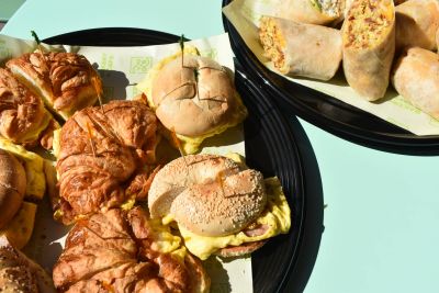 Platters of breakfast sandwiches, breakfast bagels, and breakfast burritos