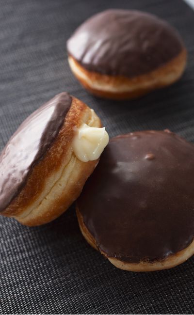 Three cream-filled pastries with chocolate glazing