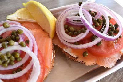 Lox Deluxe specialty bagel with cream cheese, smoked salmon, tomatoes, onions, capers, and lemon wedges