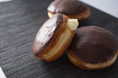 Three cream-filled pastries with chocolate glazing
